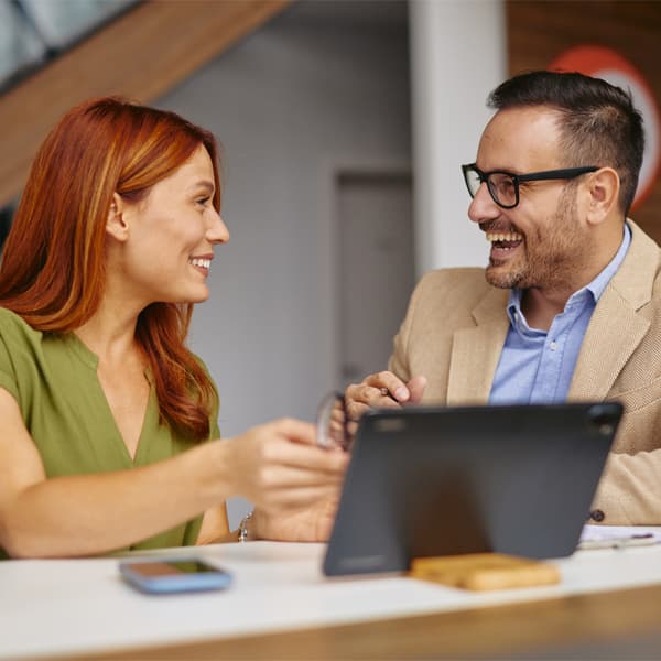 A diverse group of professionals in an office setting, engaging in a friendly meeting. The atmosphere is collaborative, promoting teamwork and positive communication among colleagues.