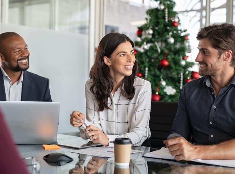 Smiling businessman and businesswoman discussing new project strategy during Xmas time.
