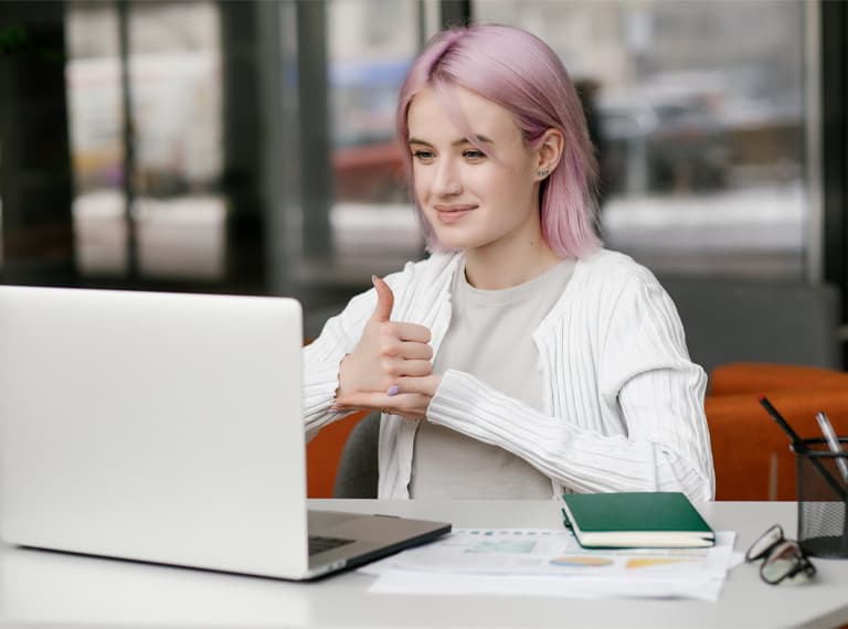 Young deaf businesswoman have digital virtual online conference with employees on computer, talking on video call, using sign language, showing gestures at screen.