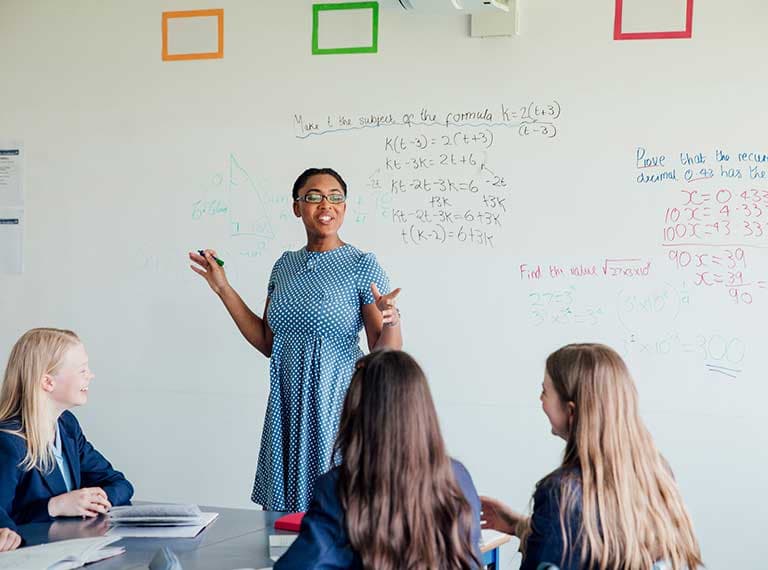 Teacher returning to the classroom teaching secondary school children