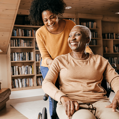 Carer looking after woman in a wheelchair in her own home