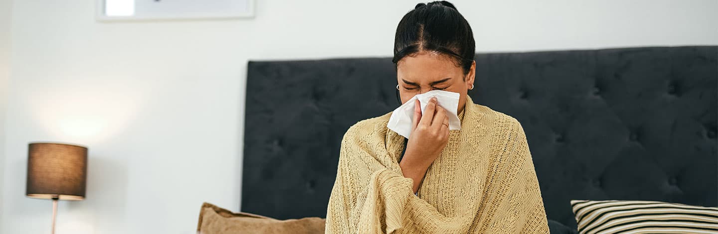 Employee blowing nose and sick in bed