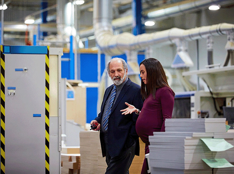 Pregnant employee discussing work with colleague